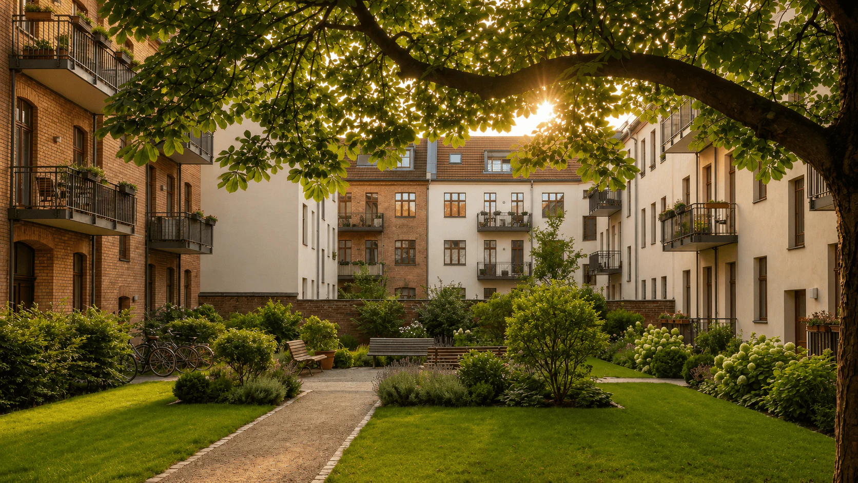 Gepflegter begrünter Innenhof einer Berliner Wohnanlage mit Gartenweg und Bäumen