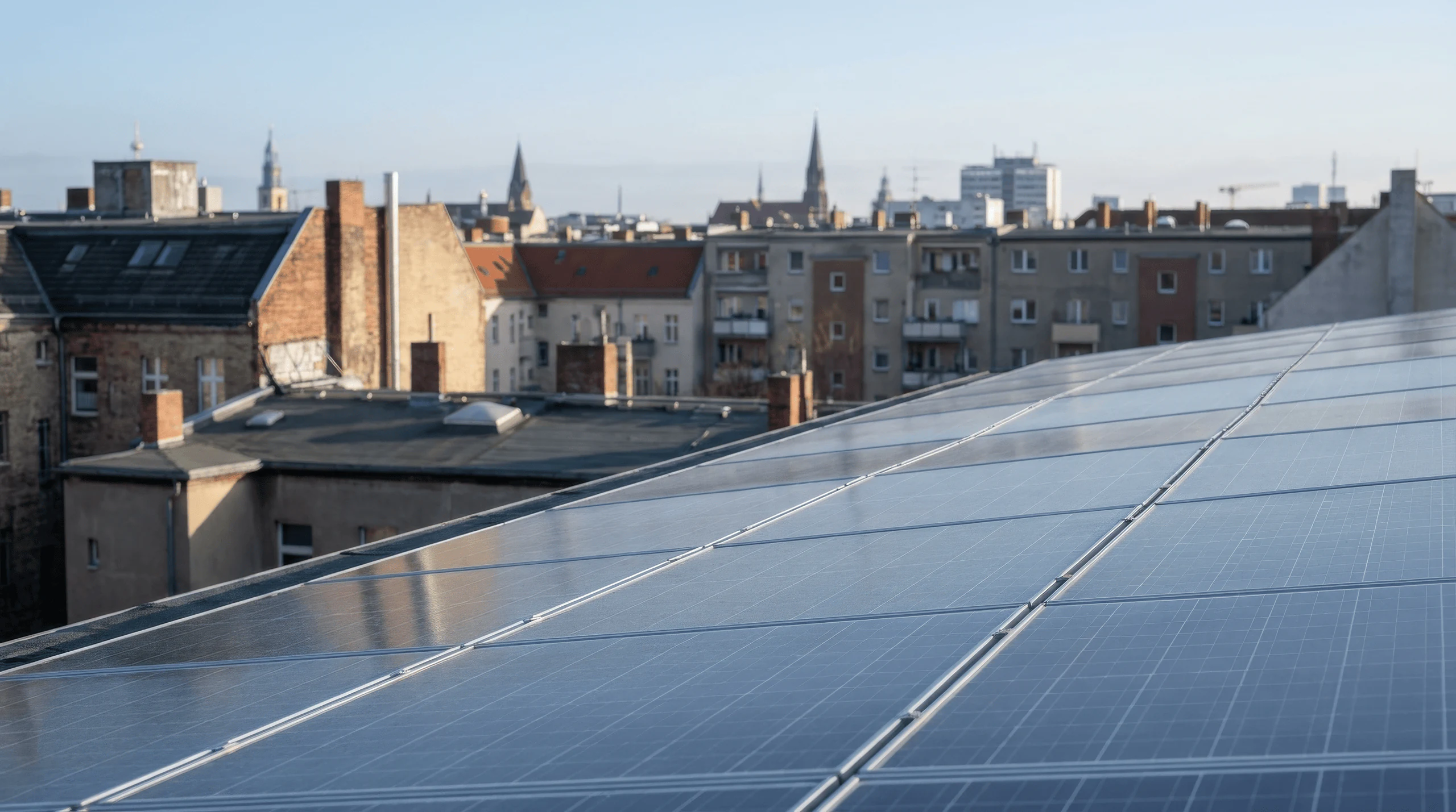 Photovoltaikmodule auf einem Berliner Dach mit Blick über die Stadt